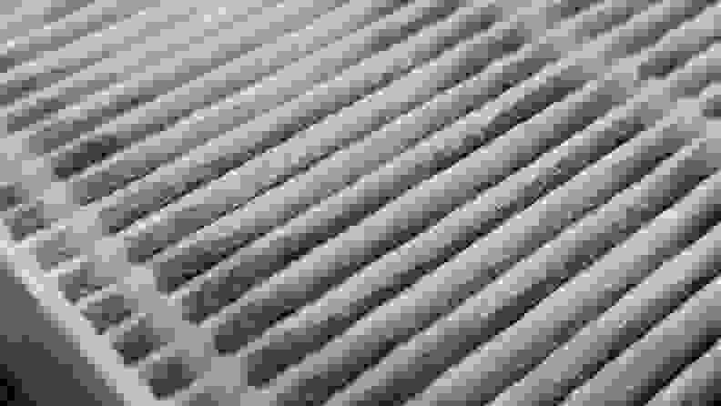 Closeup view of dirt trapped between HEPA filter fibers.