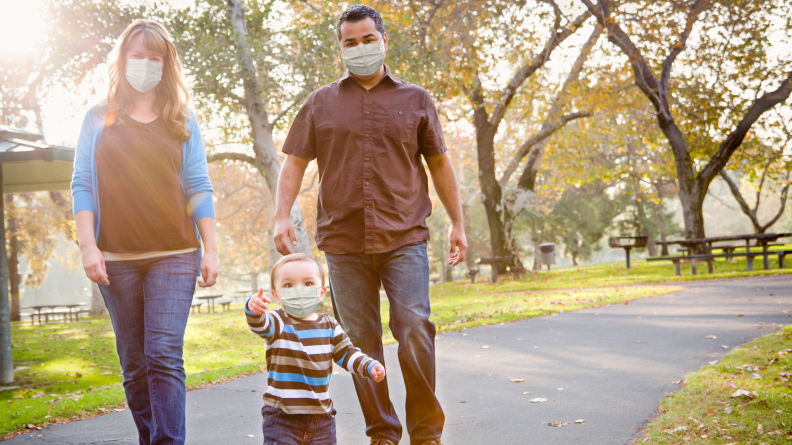 Family on a walk wearing masks.