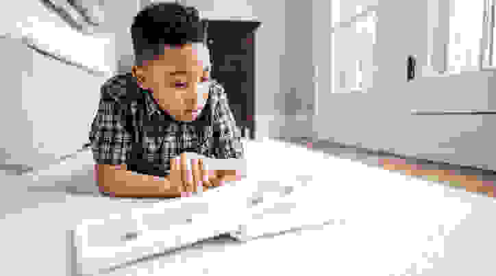 Boy reading book on floor