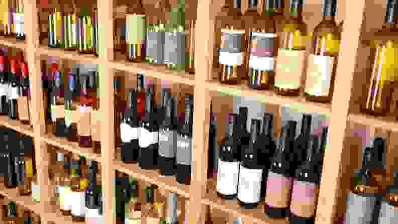 A wall of shelves lined with wine bottles at a wine shop
