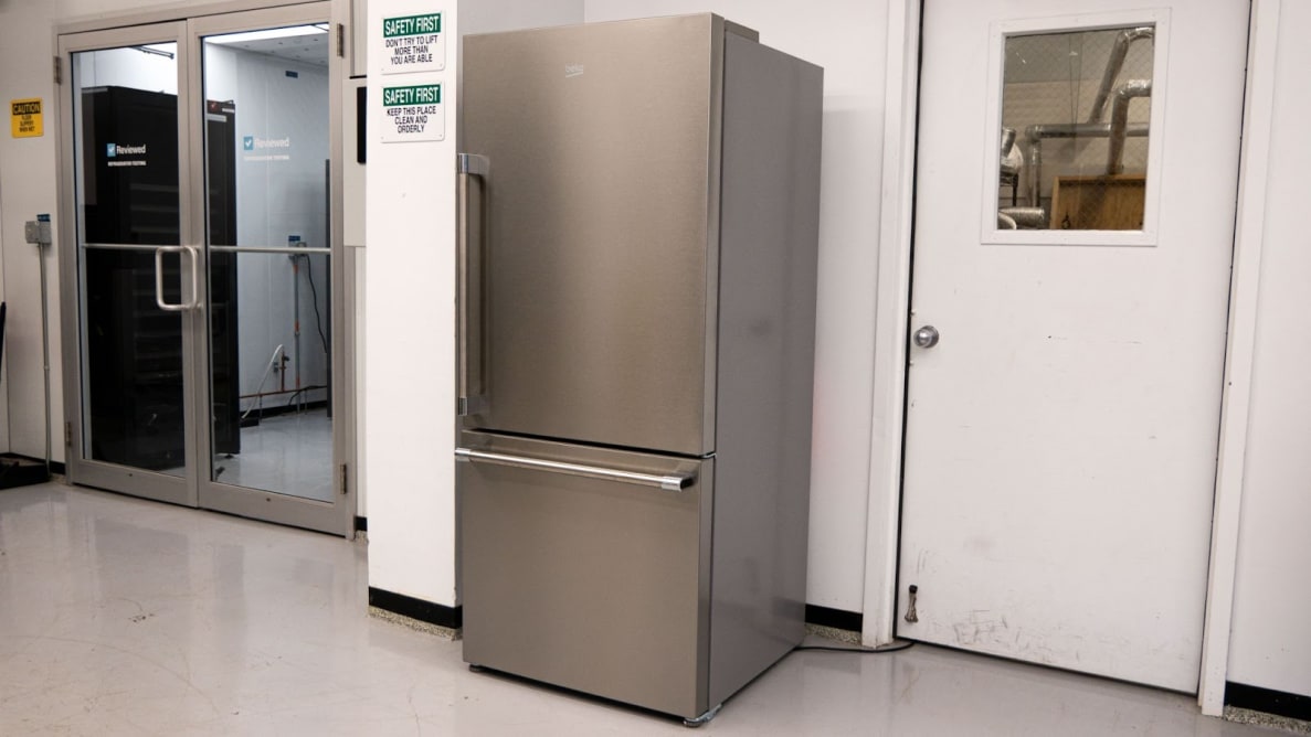 A stainless-steel refrigerator stands in a white lab environment