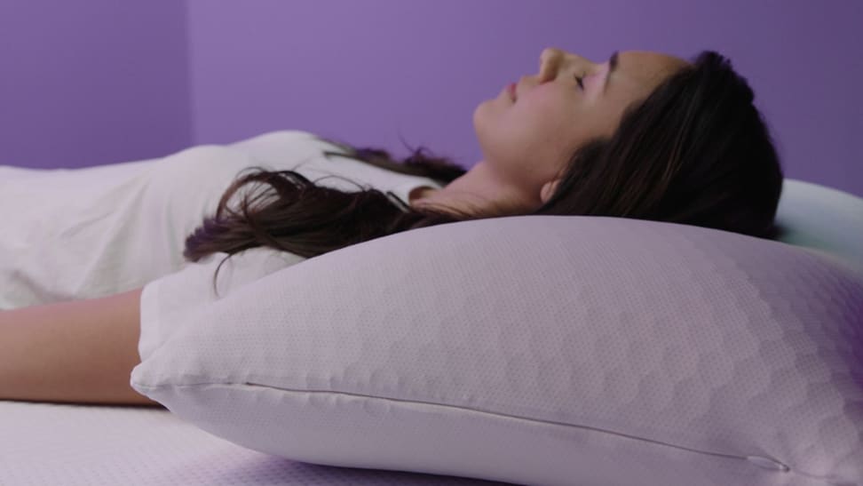 一个女人睡在她背上的紫色和谐枕头上