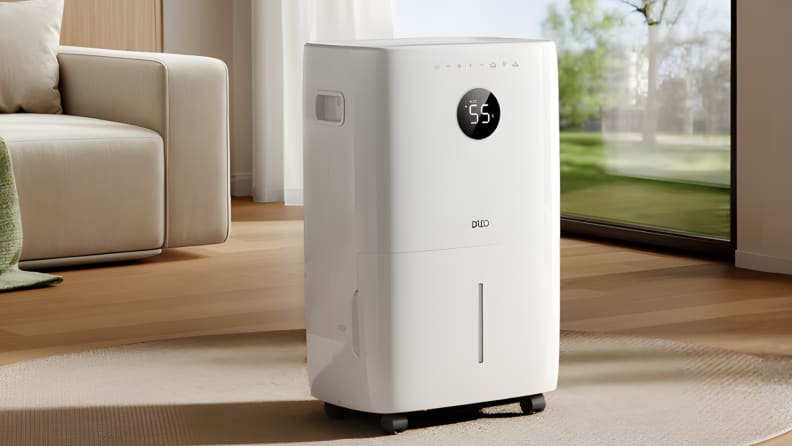 Dreo 50-pint dehumidifier placed in a living room near a side table and shelving.
