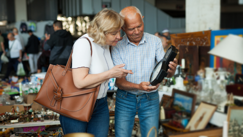 Older couple at flea market looking at home décor