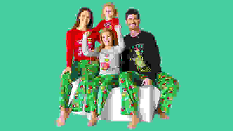 A family wearing The Grinch family matching pajama set on green background.