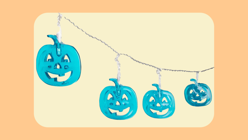 Single string of fairy lights with smiling, small, teal pumpkins as bulbs.