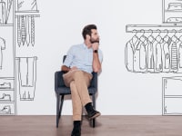 Person sitting in chair with black and white cartoon of closet drawn around them.