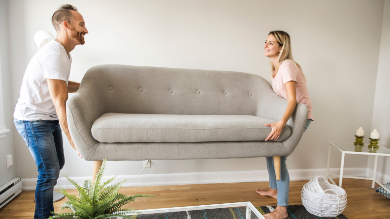 man and woman moving a couch