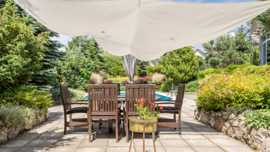 patio with table is covered by a shade sail
