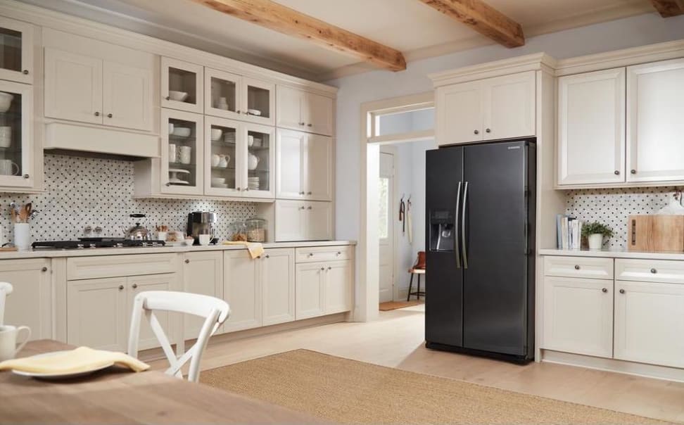 A black stainless steel refrigerator is a focal point in this white kitchen