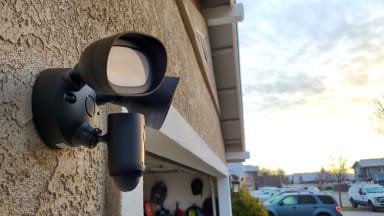 The Ring Floodlight hanging on the side of a home above a garage during the daylight