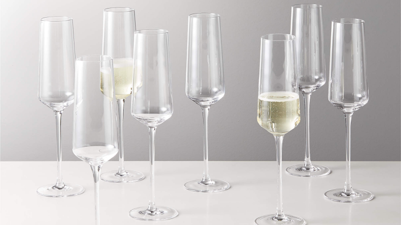 A set of angular champagne flutes against a gray background.