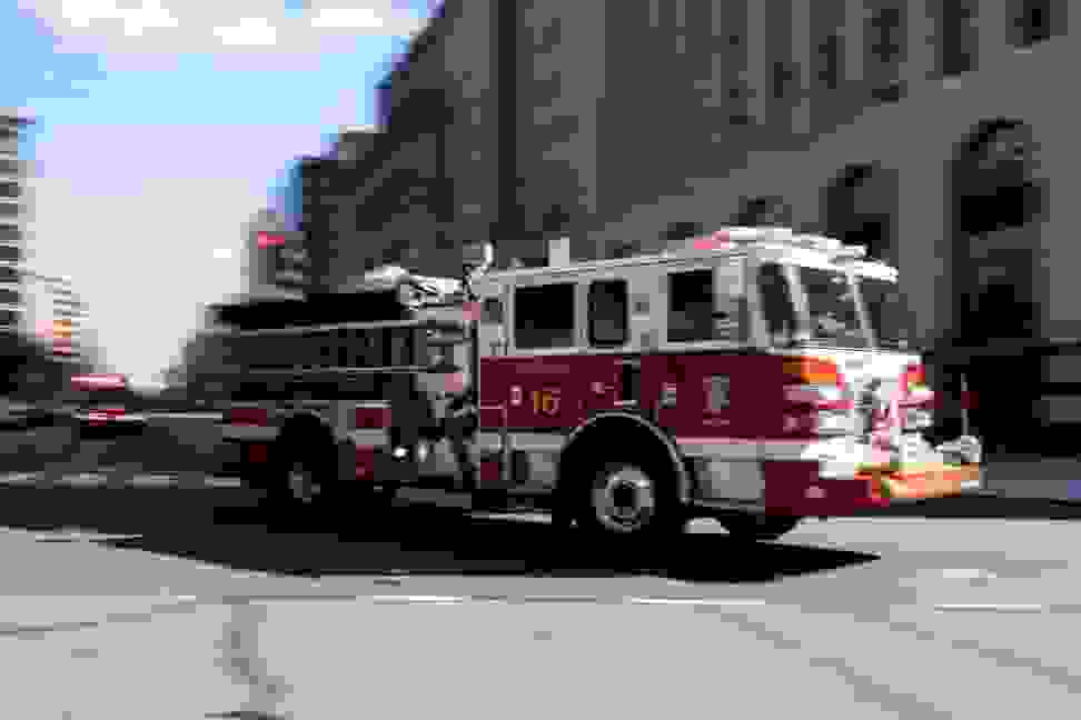 Photo of a fast-moving red-and-white firetruck.