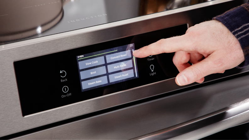 Person using finger to navigate the cooking settings on the touchscreen display of the Frigidaire Gallery GCFI3060BF 30" Induction Range.