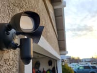 The Ring Floodlight hanging on the side of a home above a garage during the daylight