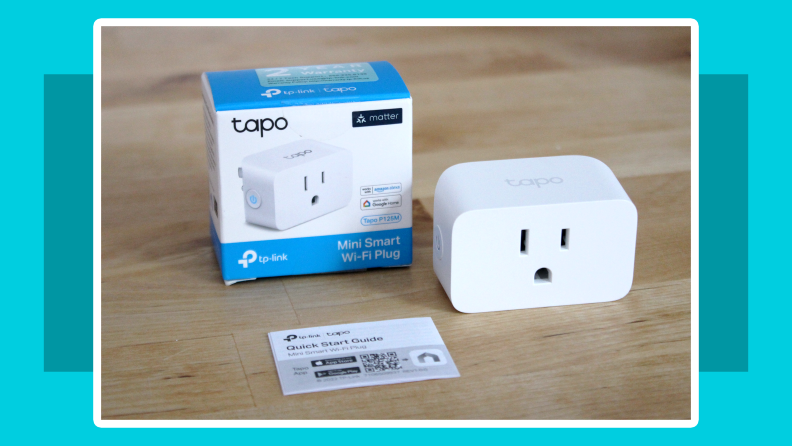 Tapo Smart Plug Mini sitting next to box packaging and instructions on top of wooden surface.