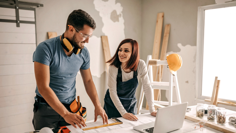 Two people smiling while completing renovation project.