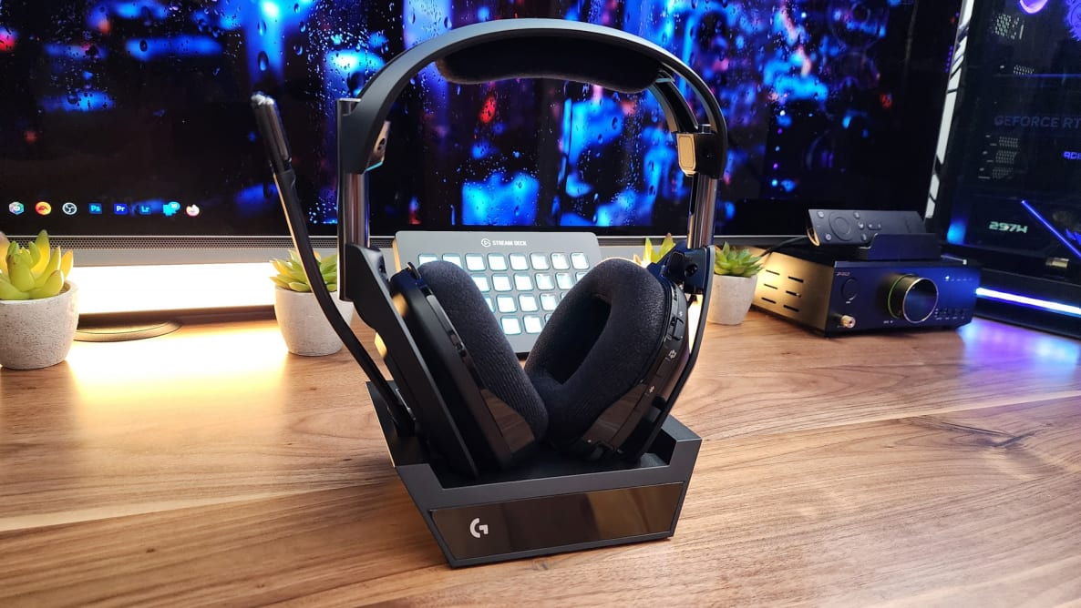 The Logitech Astro A50X headphones on its stand in front of a monitor.