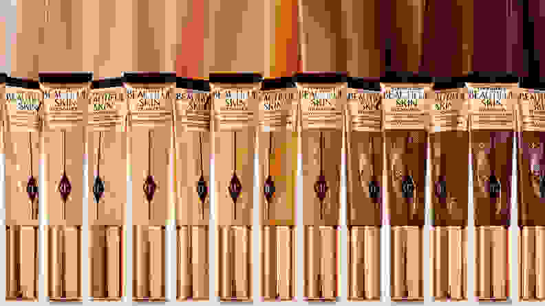 A line of foundations from light to dark shades in squeeze tubes with swatches of the shades above each bottle.