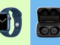 Navy blue smart apple watch next to black ear buds.