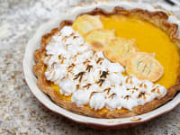 A pumpkin pie with scorched meringue and pumpkin-shaped cookies on top.