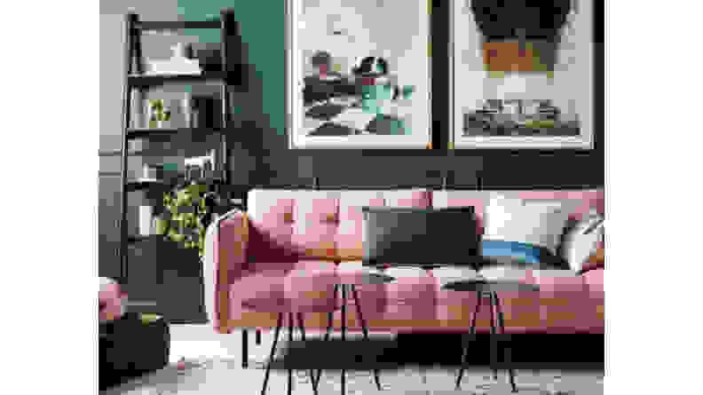 A pink couch on a dark green background