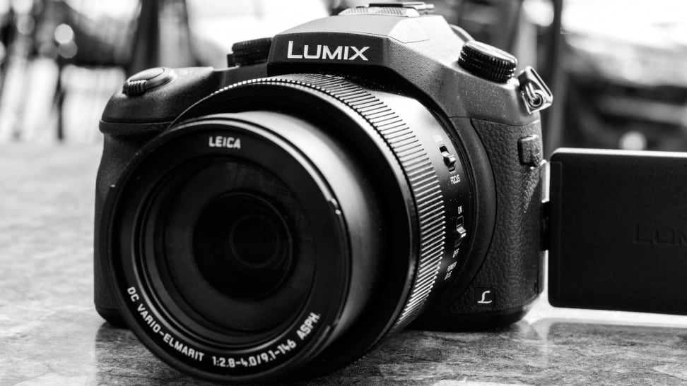 Monochrome close-up of a Lumix superzoom digital camera.