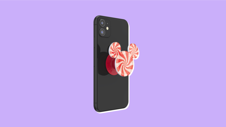 A peppermint color PopSocket in the shape of Mickey ears on an iPhone.