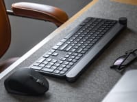 A picture of a wireless keyboard and mouse on a desk mat