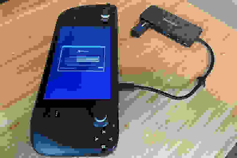 A black handheld gaming console showing part of the Windows 11 OS installation process