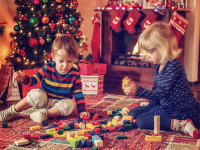 Boy and girl playing with blocks by a Christmas tree
