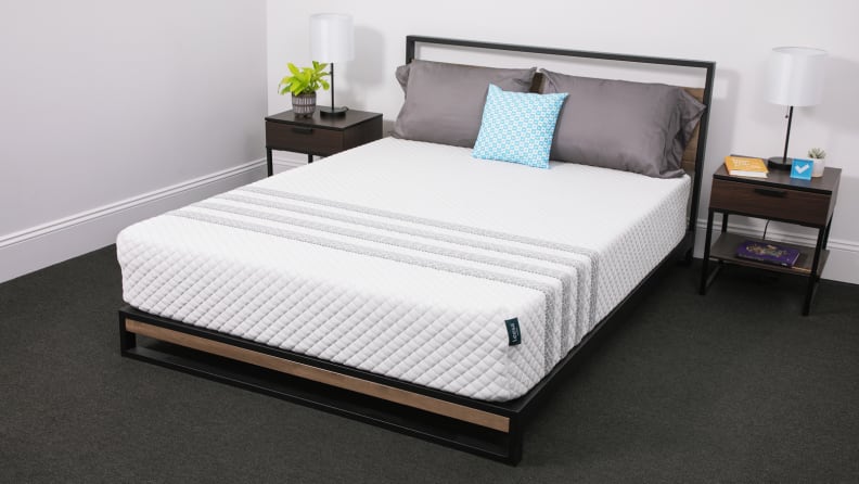 The Leesa Sapira Hybrid mattress appears in a bedroom with bedside tables on either side.