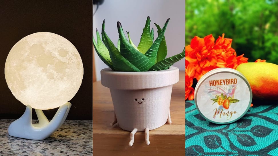 On left, white hand holding faux moon night light. In middle, smiley face planter with succulent inside. On right, hydrating hand lotion next to mango and orange flower.