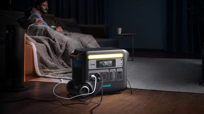 Couple laughing on couch indoors next to the Anker PowerHouse 767 Portable Power Station.