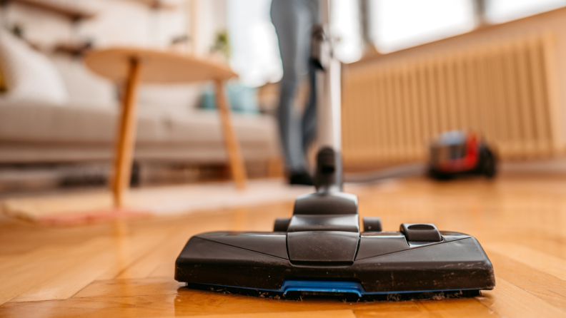 A close-up shot of hardwood floors being vacuumed.