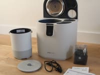 The Vitamix Eco 5 FoodCycler next to a plastic measuring cup with compost in it.