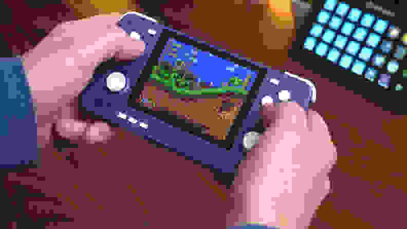 Person holds the A view of the Retroid Pocket 2S handheld while playing video game.