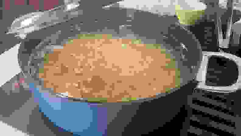 A shallow casserole pan boiling water and pasta.