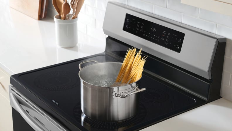 A pot with spaghetti noodles sits atop a convection range.