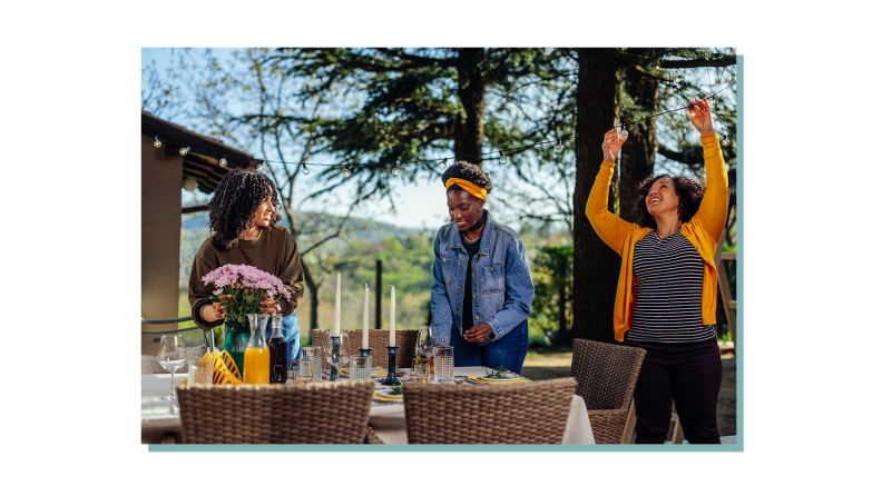 A group of people setting up their patio table and lights.