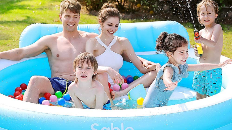 Family sitting in a sable pool