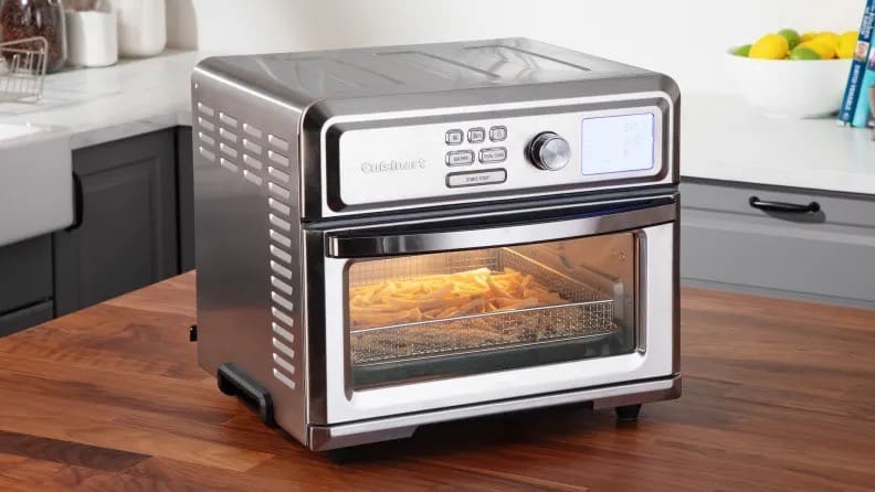 The Cuisinart Digital Air Fry Oven on a wood counter with french fries inside.