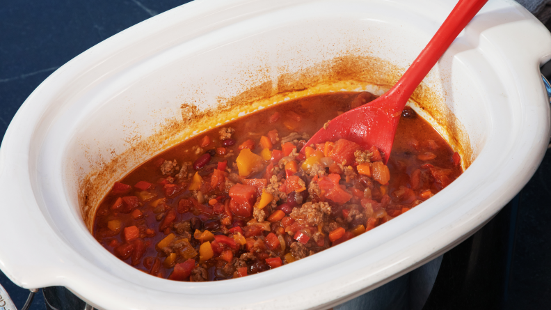 Silicone spatula in a slow cooker full of chili