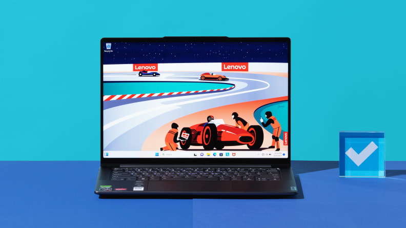 Открытый ноутбук с включенным питанием, на экране которого изображен красный гоночный автомобиль на синем фоне.