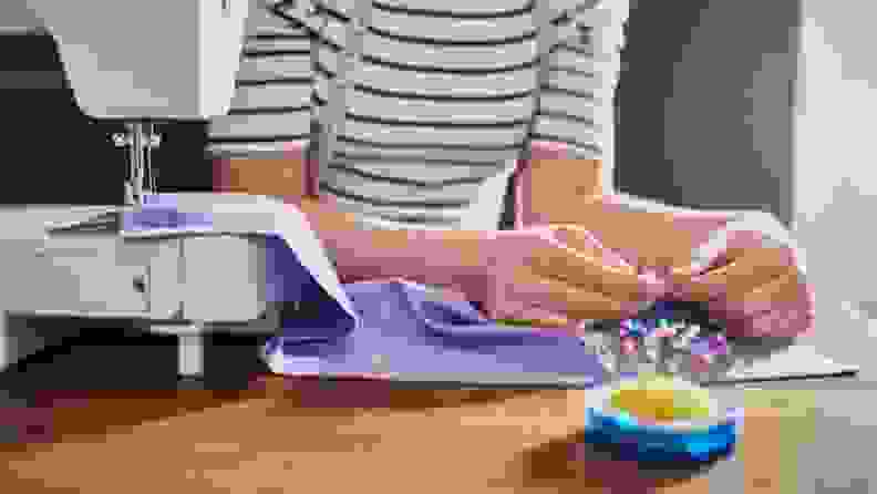 a woman sews purple cloth