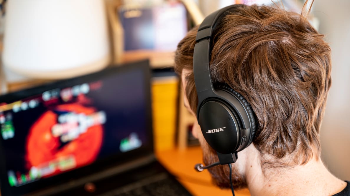 A person wearing a headset sitting in front of a computer