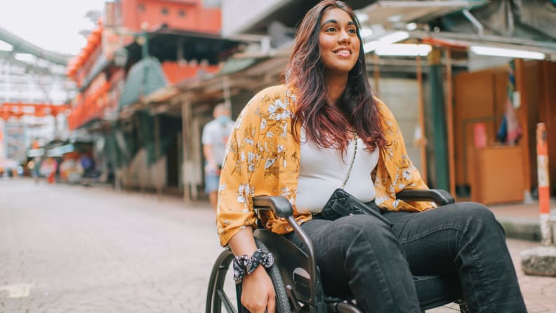 Person smiling while sitting in wheel chair.