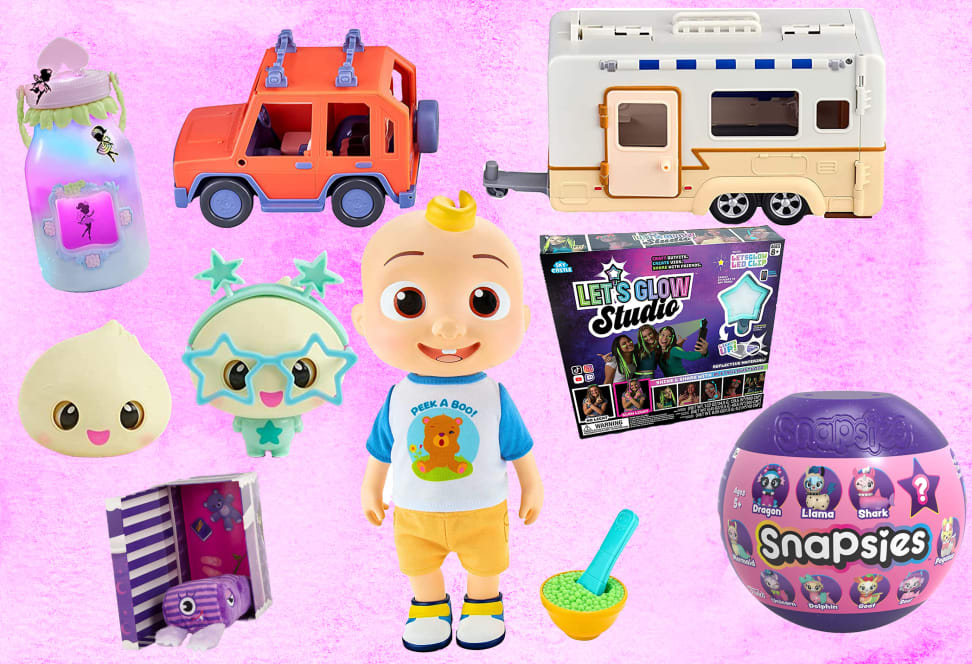 Assorted children's toys in front of pink background.