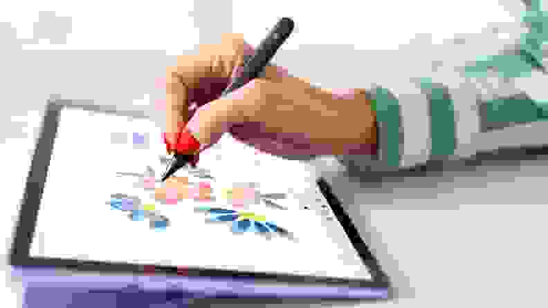 A hand with a drawing pen using the Windows Surface in Windows S Mode.