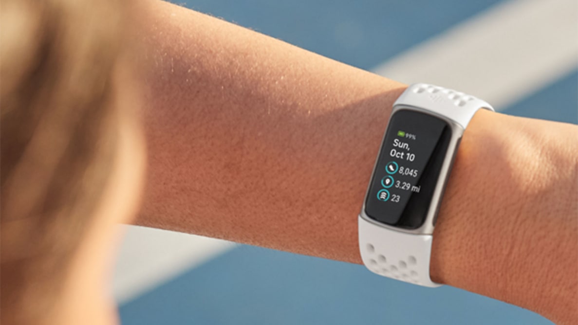 A person looking at their Fitbit Charge 5 on their wrist.